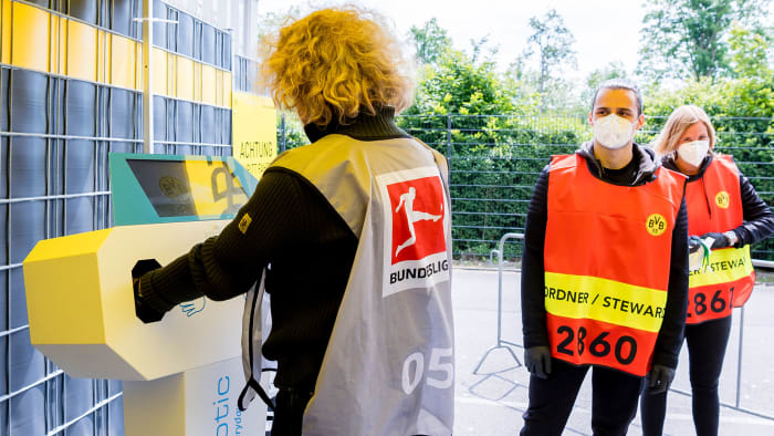 Stadium stewards sanitize their hands before Dortmund vs. Schalke